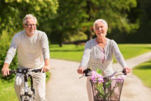 two older adults ride bikes as they experience health and wellness trends in senior living
