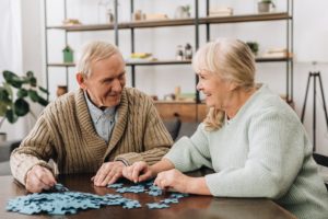 elderly couple working a jigsaw puzzle while discussing 5 differences between assisted living and memory care