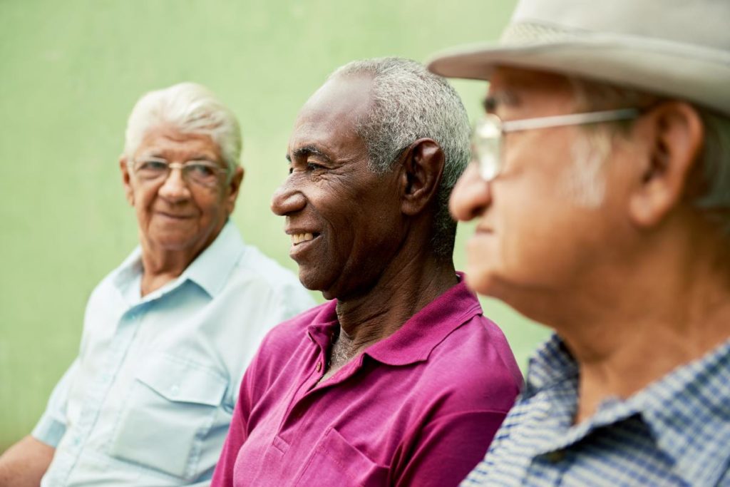 three older men sitting together and discussing the differences between assisted living and an independent facility