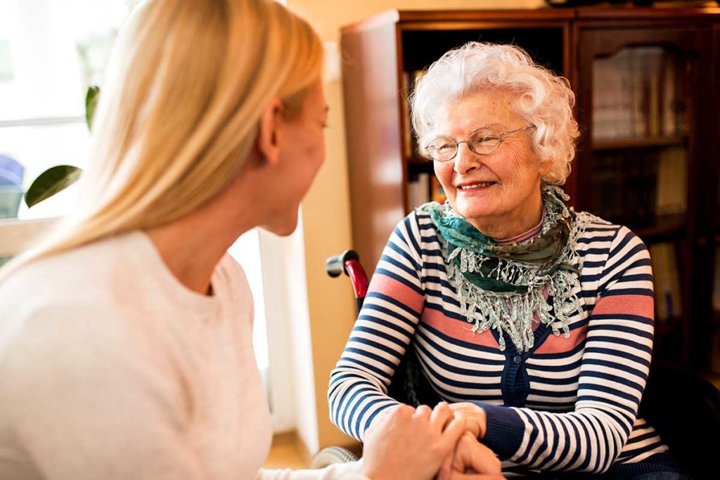younger woman explaining to older relative whats the difference between assisted living and memory care