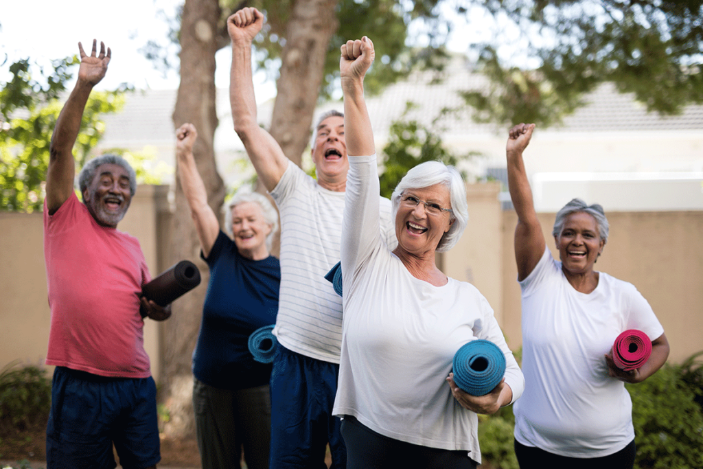 group of seniors enjoying the benefits of active senior living communities by exercising in a group outdoors