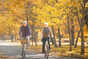 senior man and woman riding bikes on a crisp autumn day engaging in fun fall activities for seniors