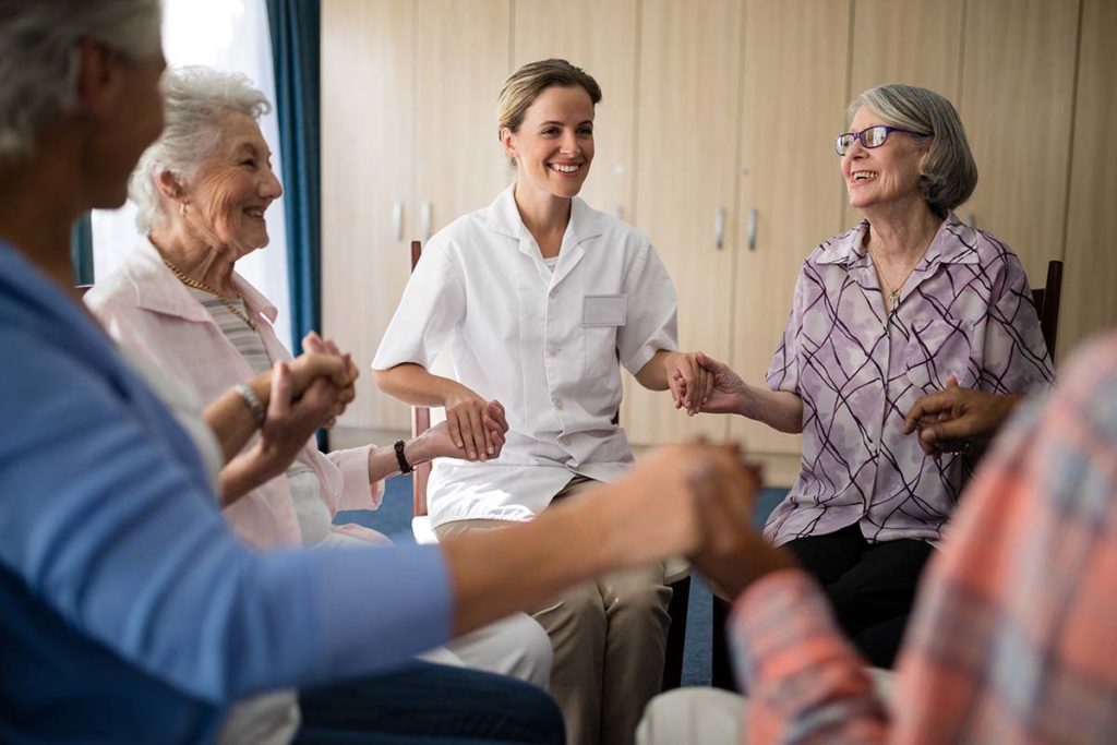 group of senior citizens standing in a circle participating in fun activity while realizing why respite care is beneficial for seniors