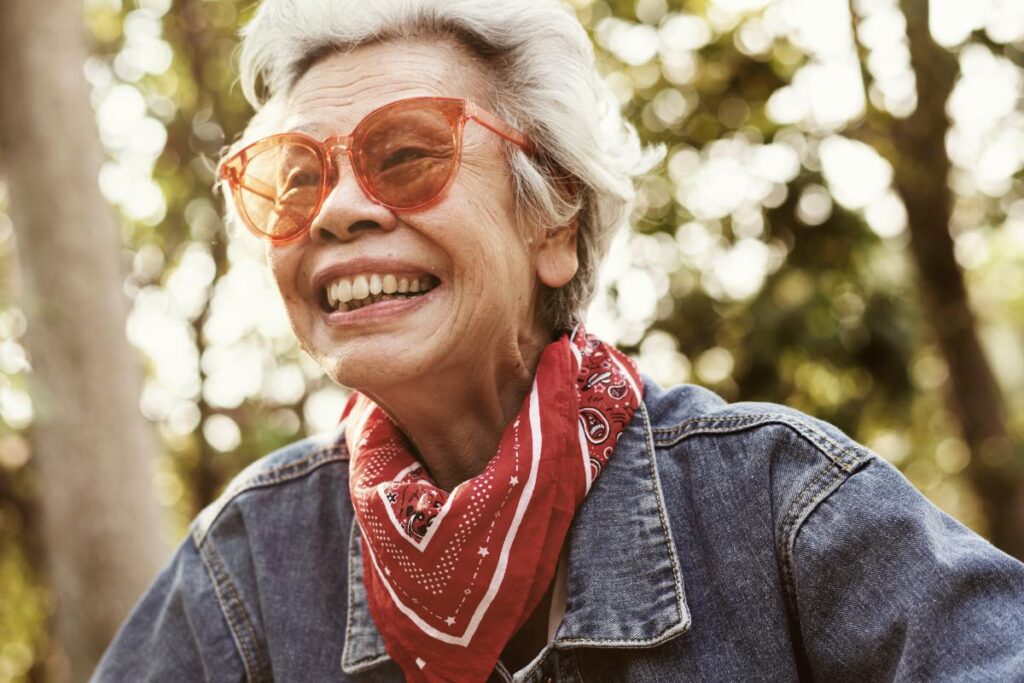 smiling female senior citizen going for a walk outside on a sunny day after learning how to promote independence in seniors