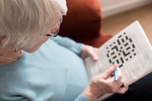 a senior does a crossword as an exercise to improve memory