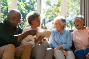 a group of seniors laughs and talks about the benefits of senior independent living