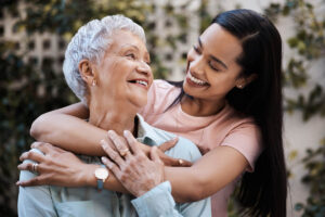 an adult child embraces a senior parent as they talk about the best age for senior independent living