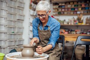 an active and engaged senior citizen participates in a pottery class after her daughter asked, "what can my senior parent do for fun?"
