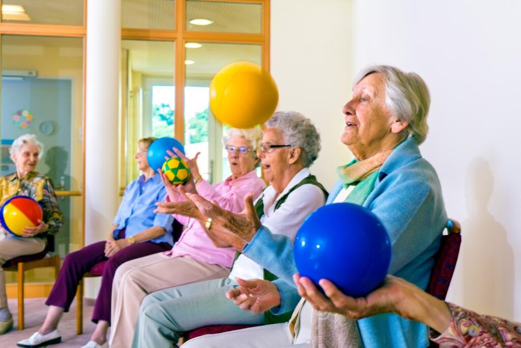 group of senior men and women enjoying senior living activities in a senior community by playing games and exercising