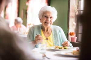 female senior citizen seated at table with other seniors preparing to eat after wondering what are the meals like in senior living