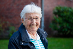 smiling older woman maintaining independence in senior living community.