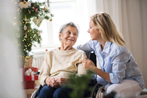 middle-aged woman seated with her mother is staying connected to senior loved ones during the holidays.